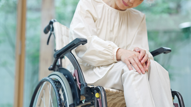 関節が痛い車椅子のシニア女性