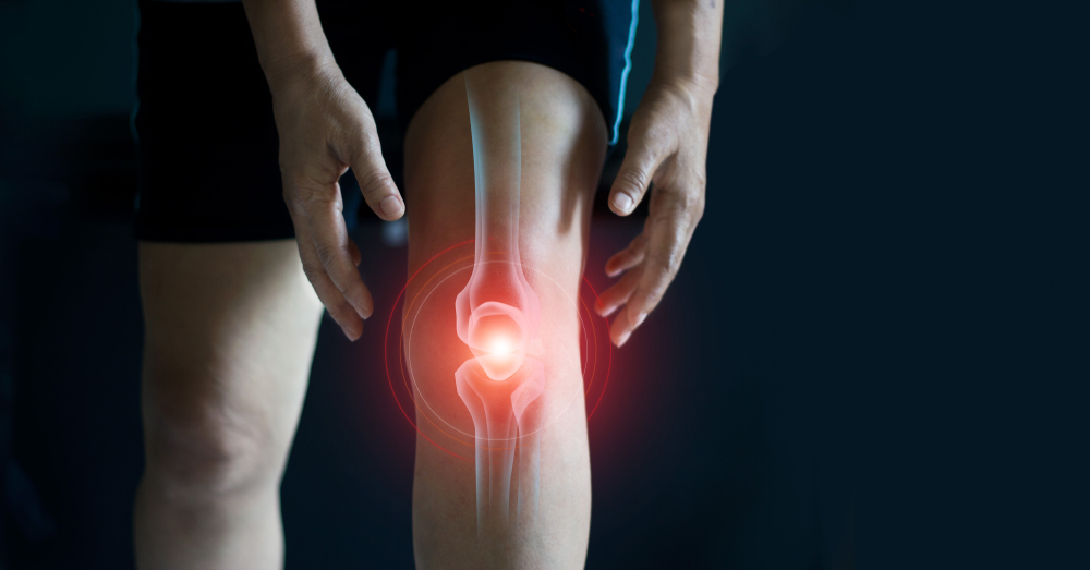 膝の痛みに苦しむ老女。暗い背景に腱の問題と関節の炎症。