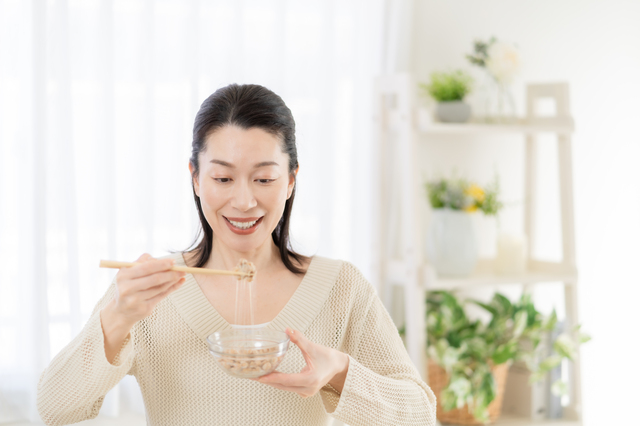 納豆を食べる中年女性